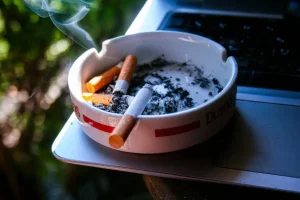 تصویری از جا سیگاری با دو سیگار در آن